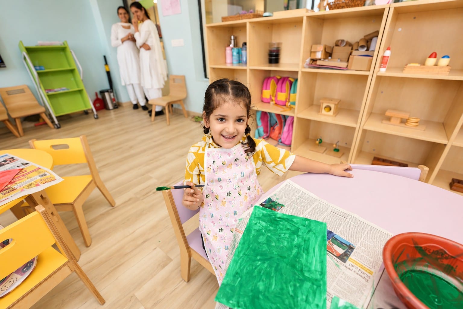 A girl painting at her easel table