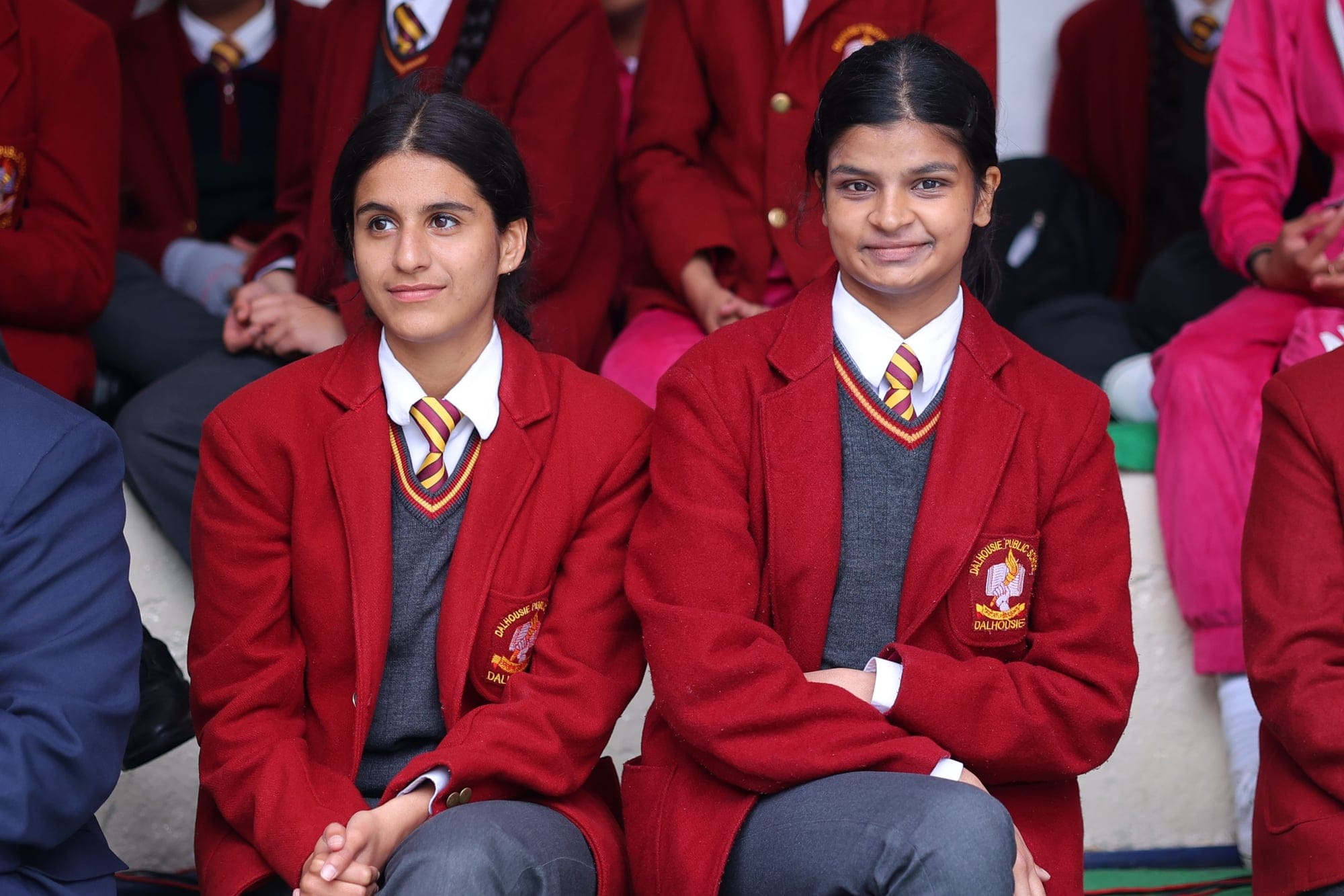 Two students smiling at an assembly
