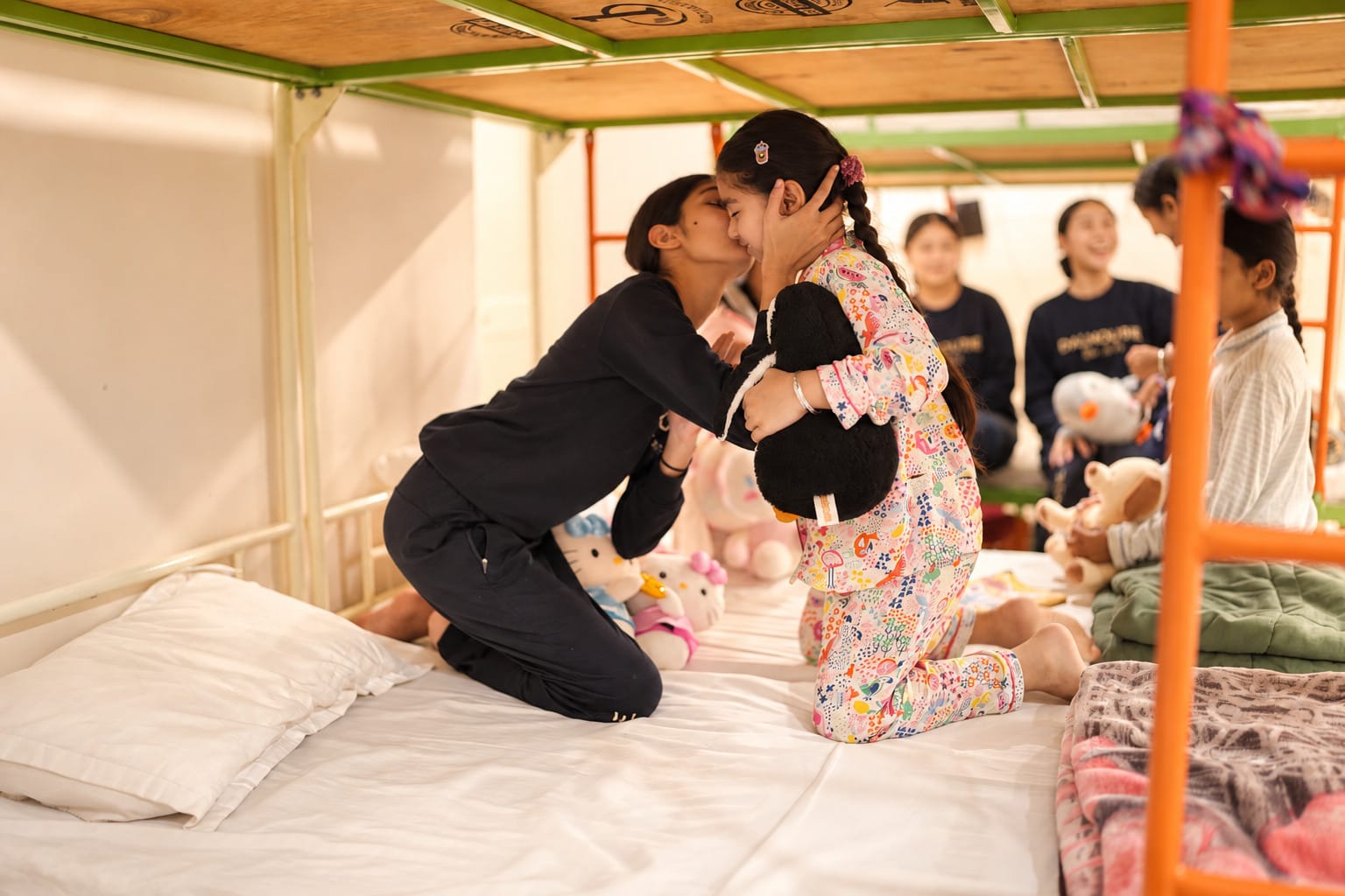 Two girls sharing a hug in the dormitory