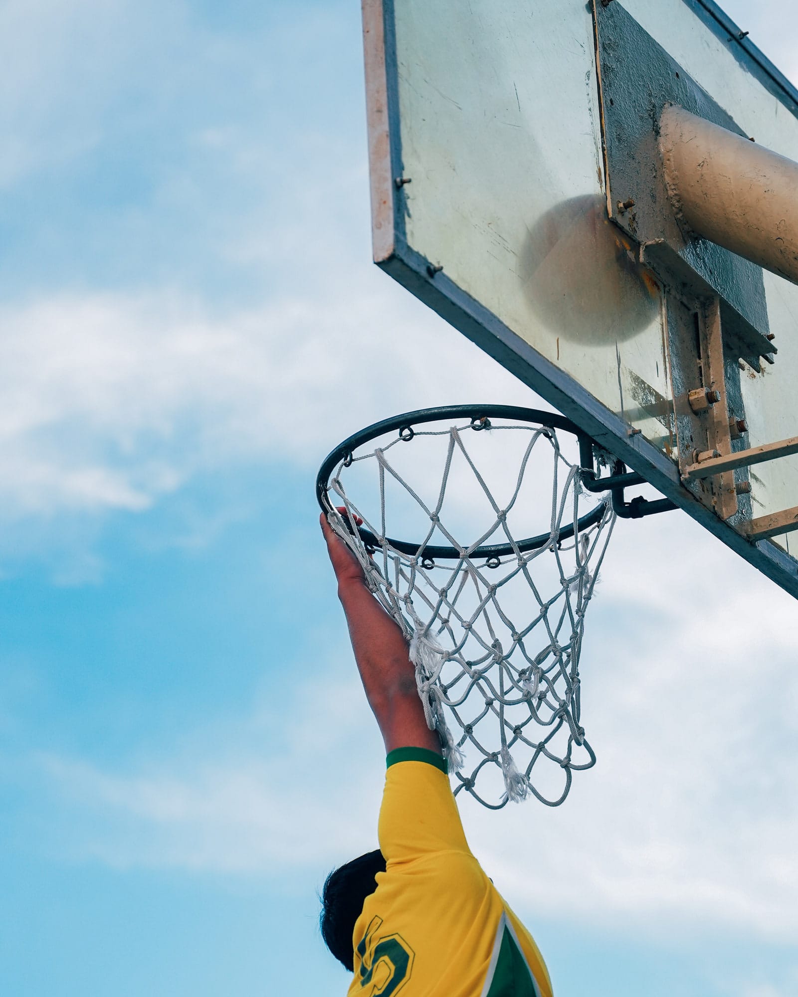 A student reaching for the basketball hoop